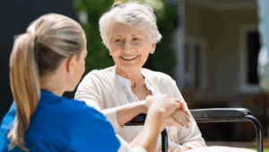 a senior lady and her caregiver holding hands